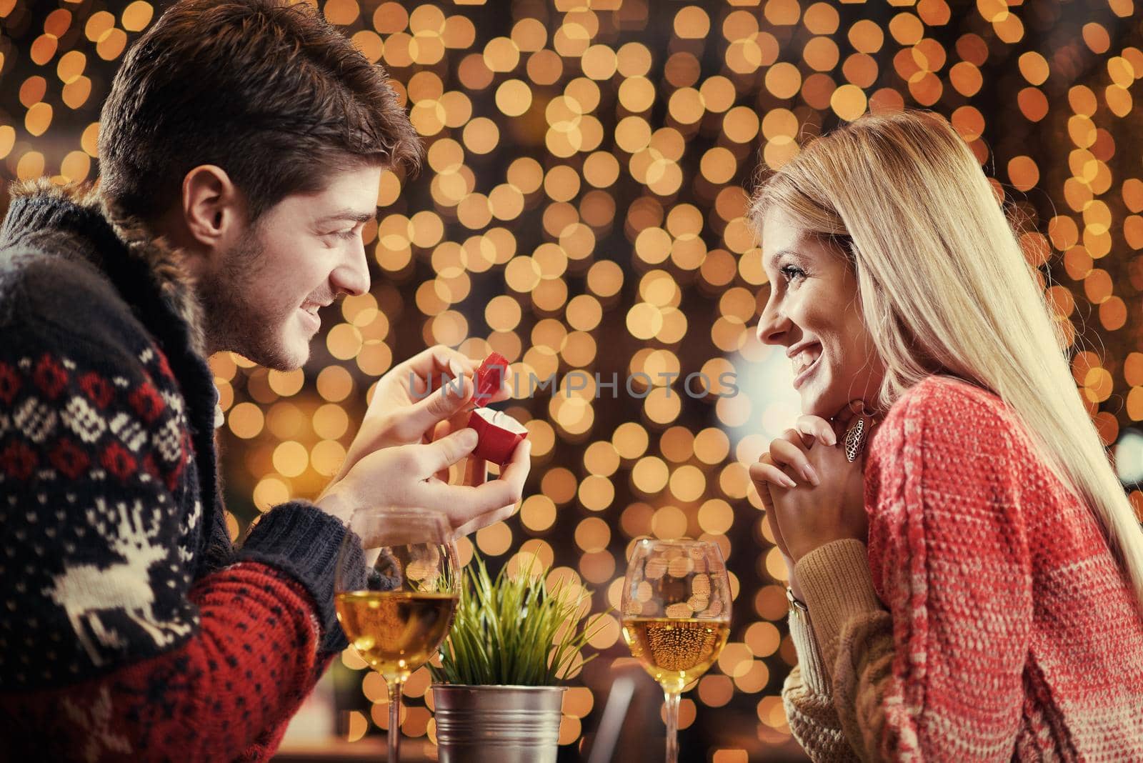 The young man gives a wedding ring   gift to  girl in restaurant