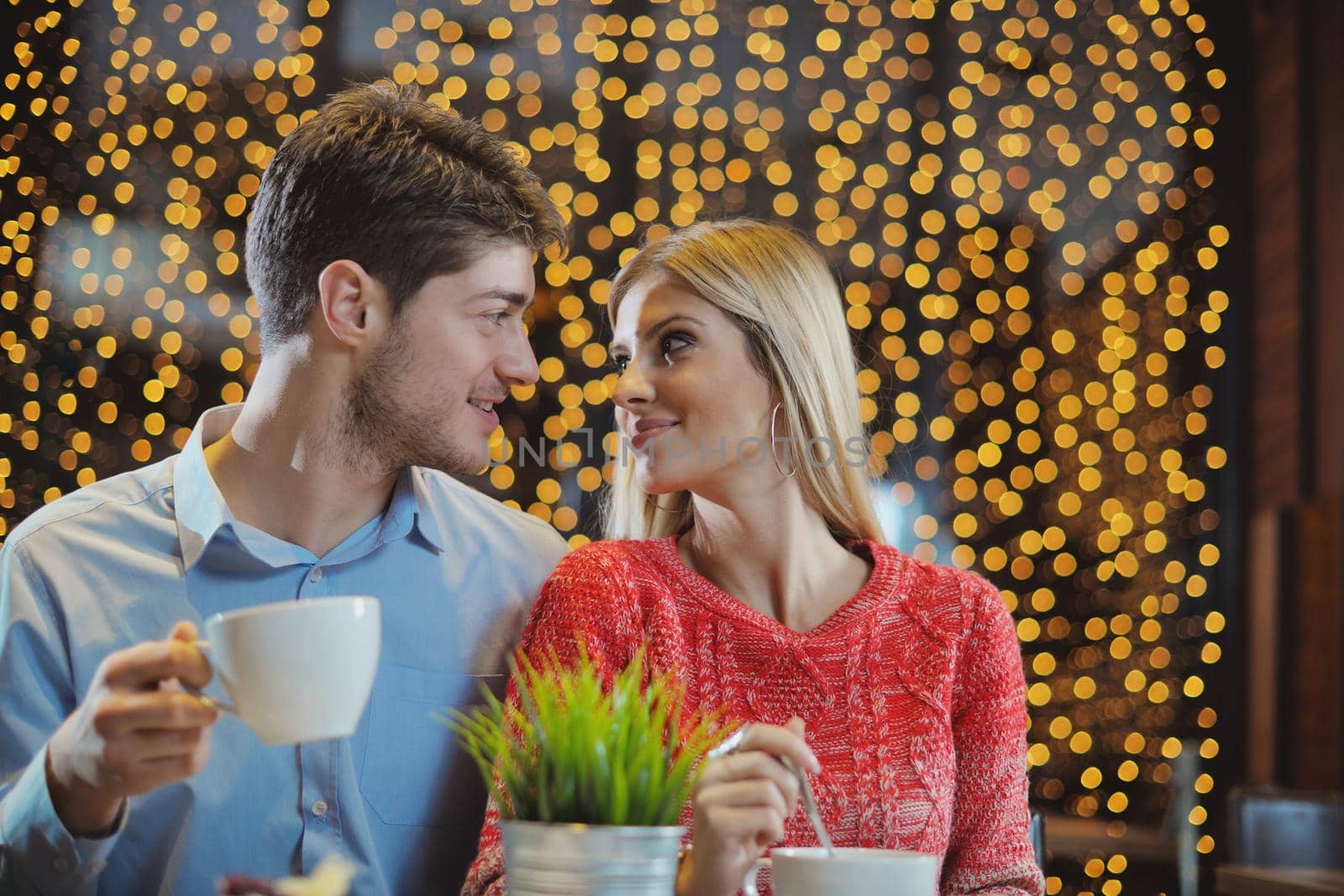 romantic evening date in restaurant  happy young couple with wine glass tea and cake