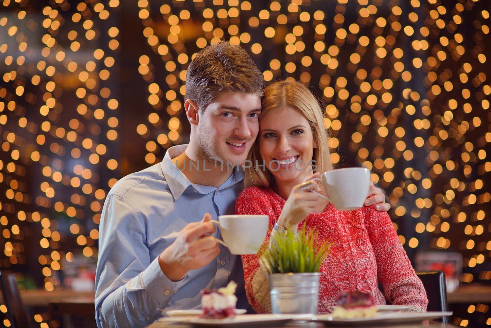 romantic evening date in restaurant  happy young couple with wine glass tea and cake