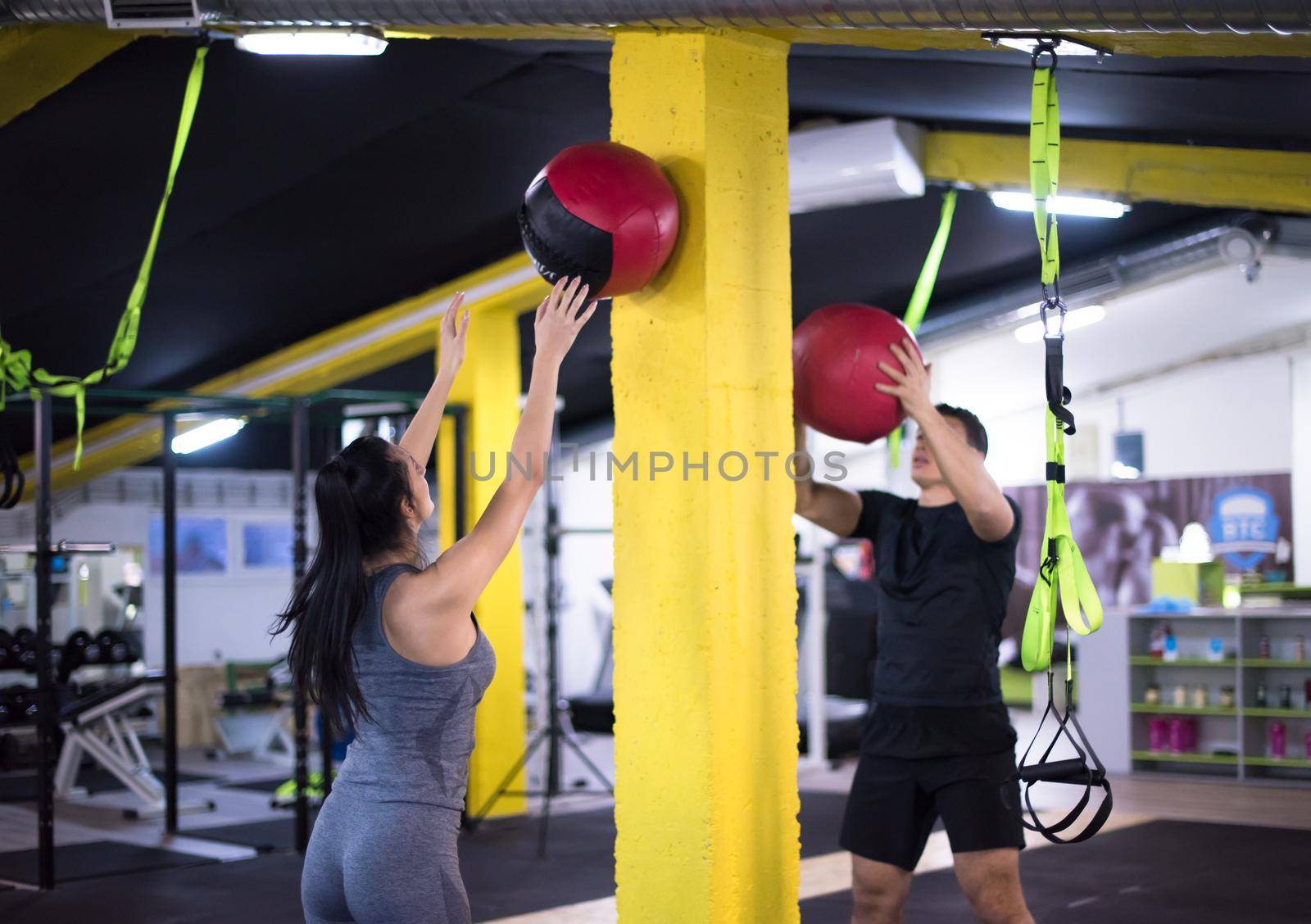 young athletes couple working out with medical ball by dotshock