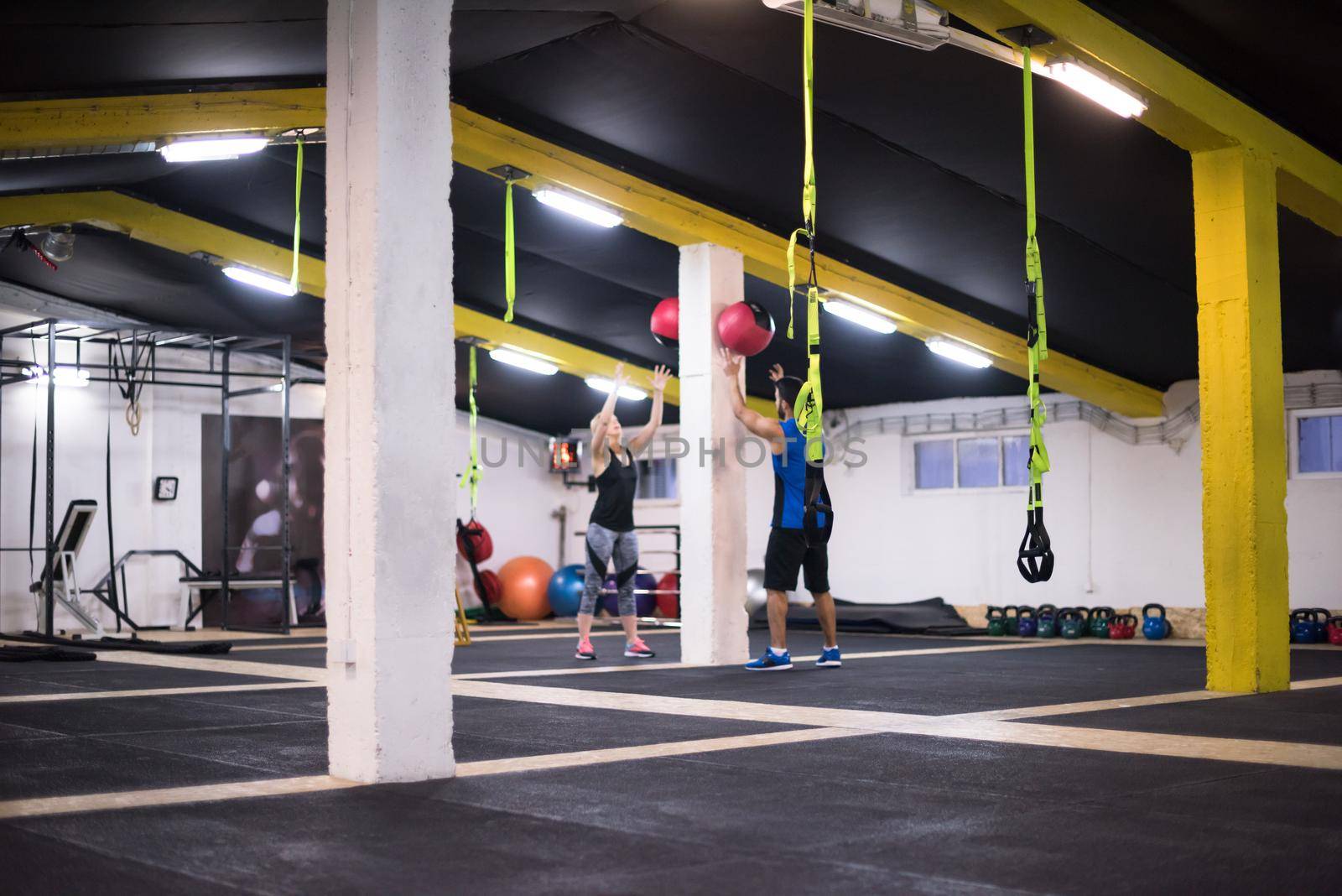 young athletes couple working out with medical ball by dotshock