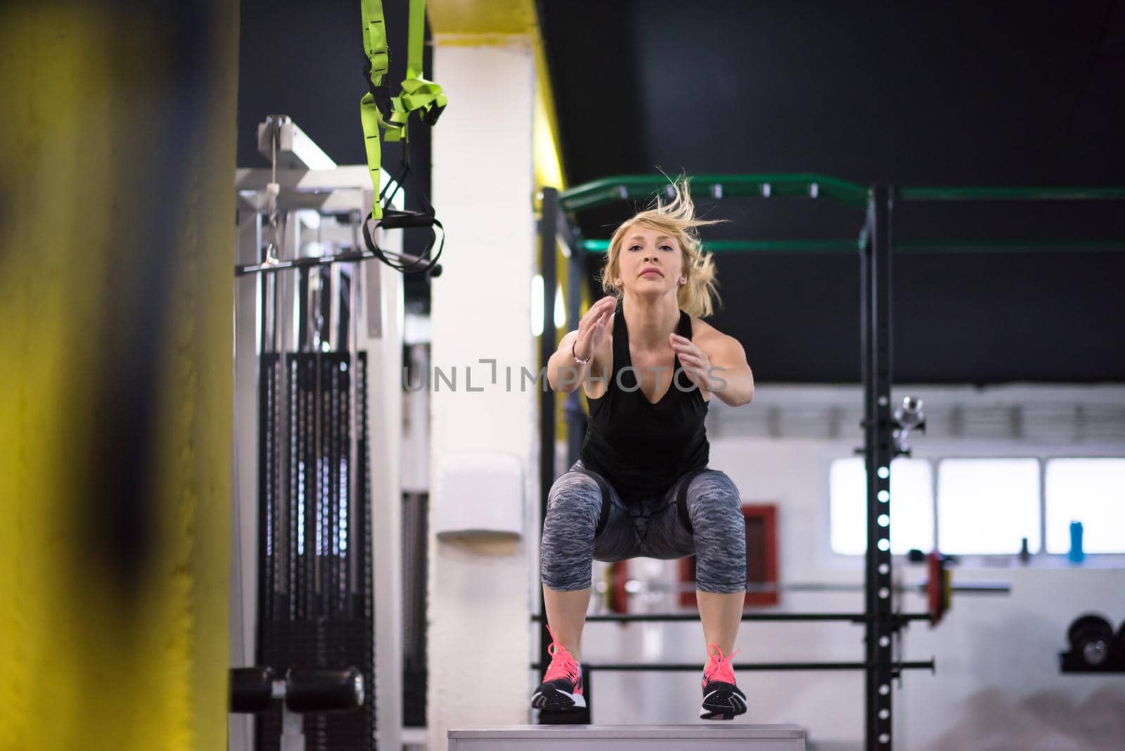 young athletic woman training  jumping on fit box at cross fitness gym