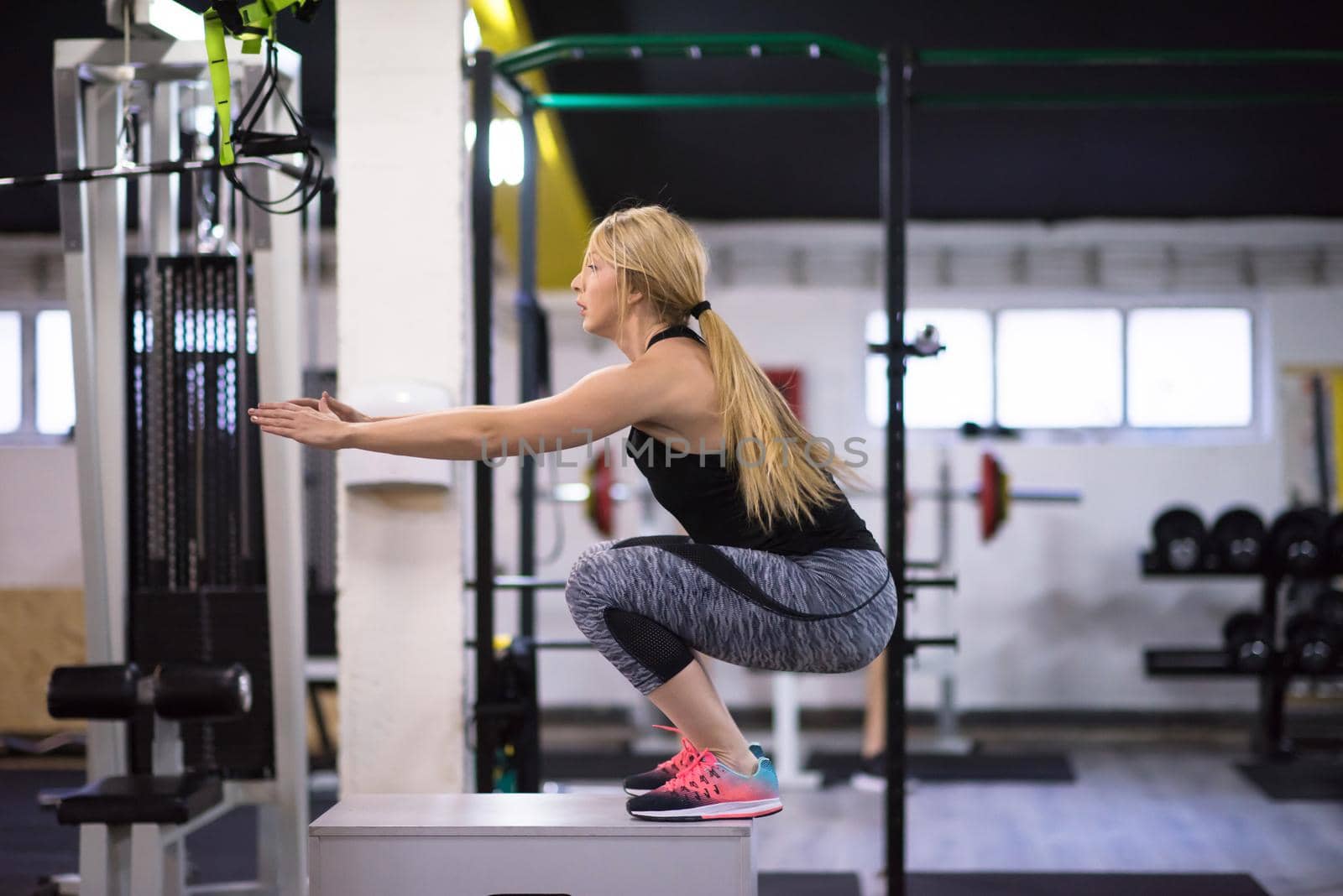 young athletic woman training  jumping on fit box at cross fitness gym