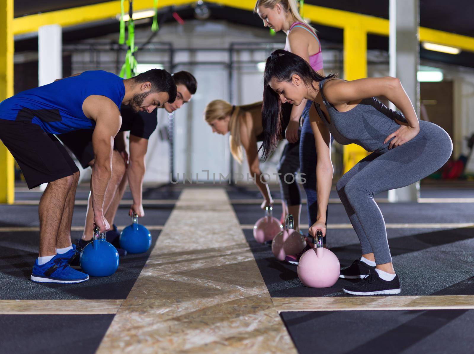 athletes doing exercises with kettlebells by dotshock