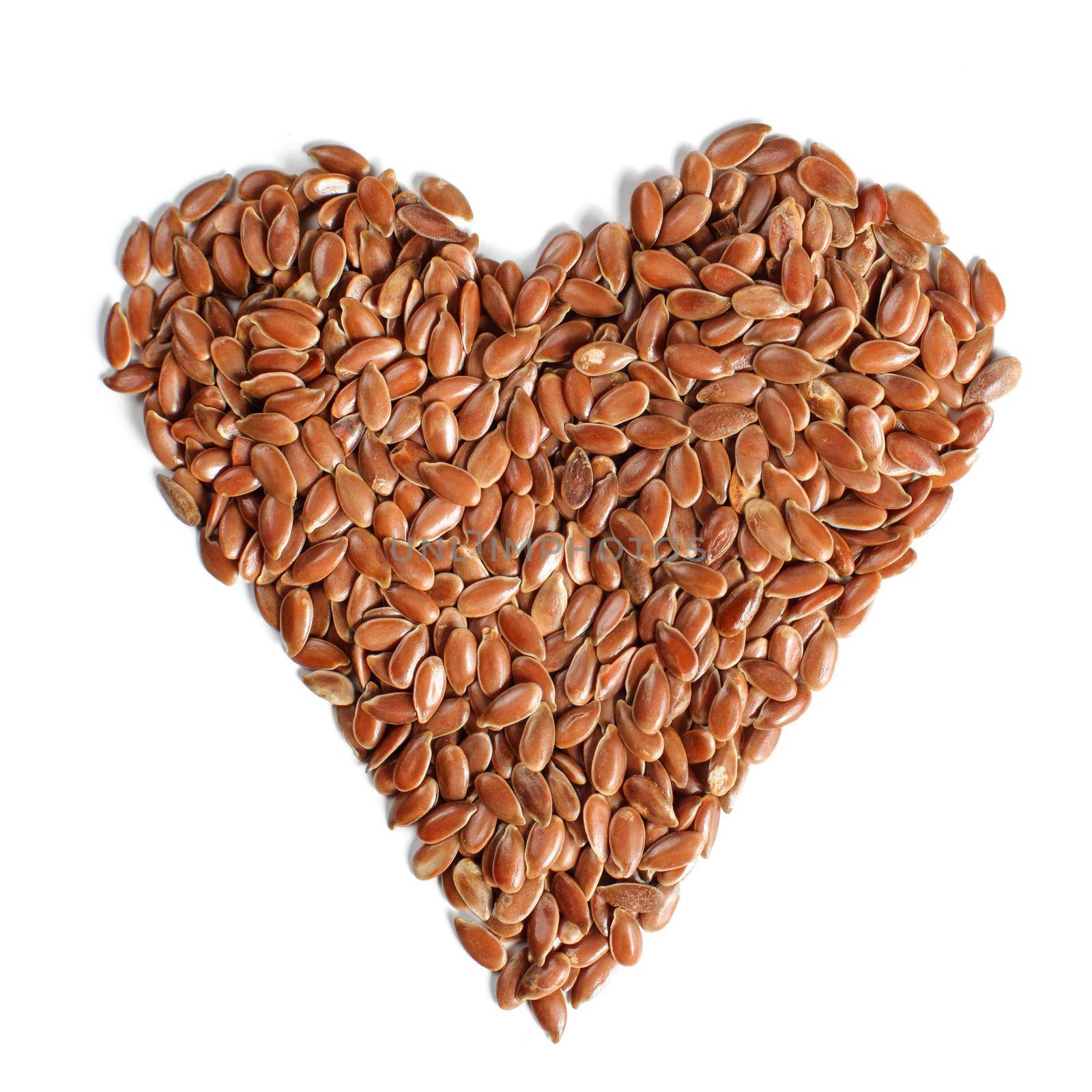 Heart made of flax seeds (Linum usitatissimum) view from above, isolated on white background. Food good for healthy heart concept. by Ivanko