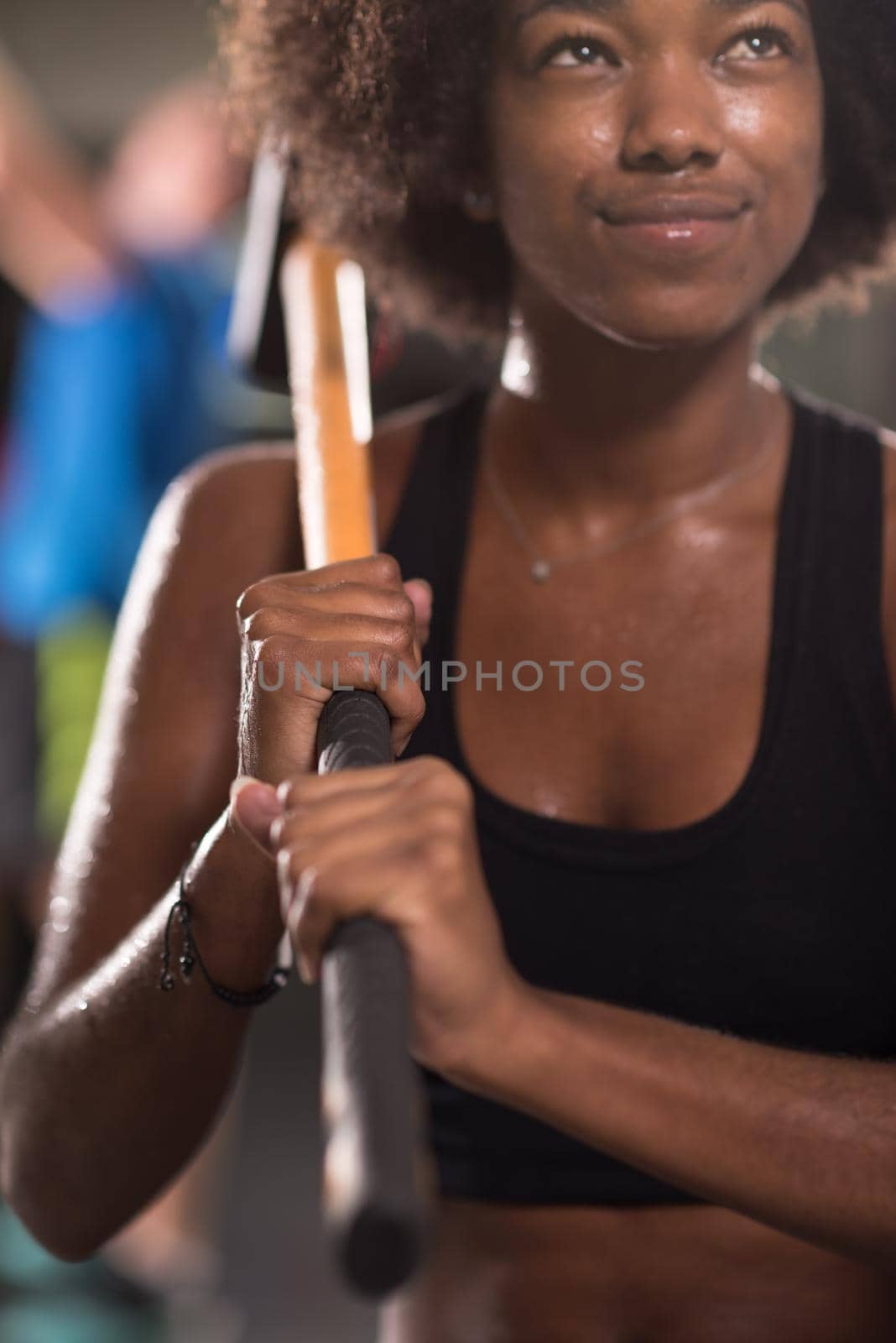 portrait of a young beautiful African American woman after training with a sledgehammer and tractor tire