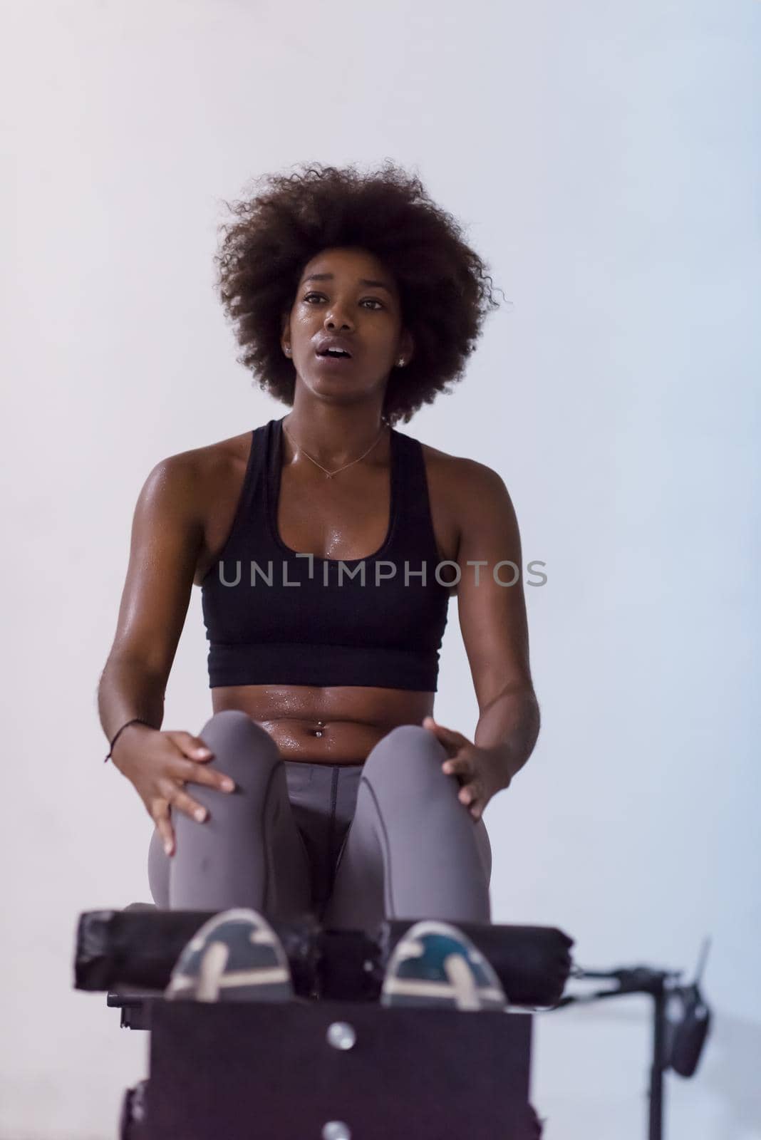black woman doing sit ups at the gym by dotshock