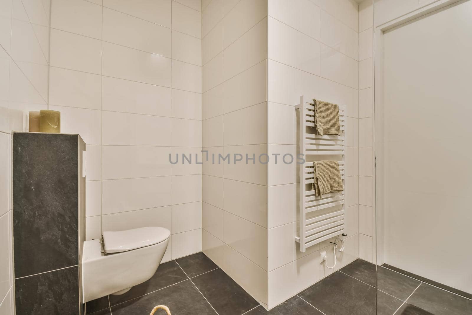 Luxurious restroom with candle shelf and hanging toilet