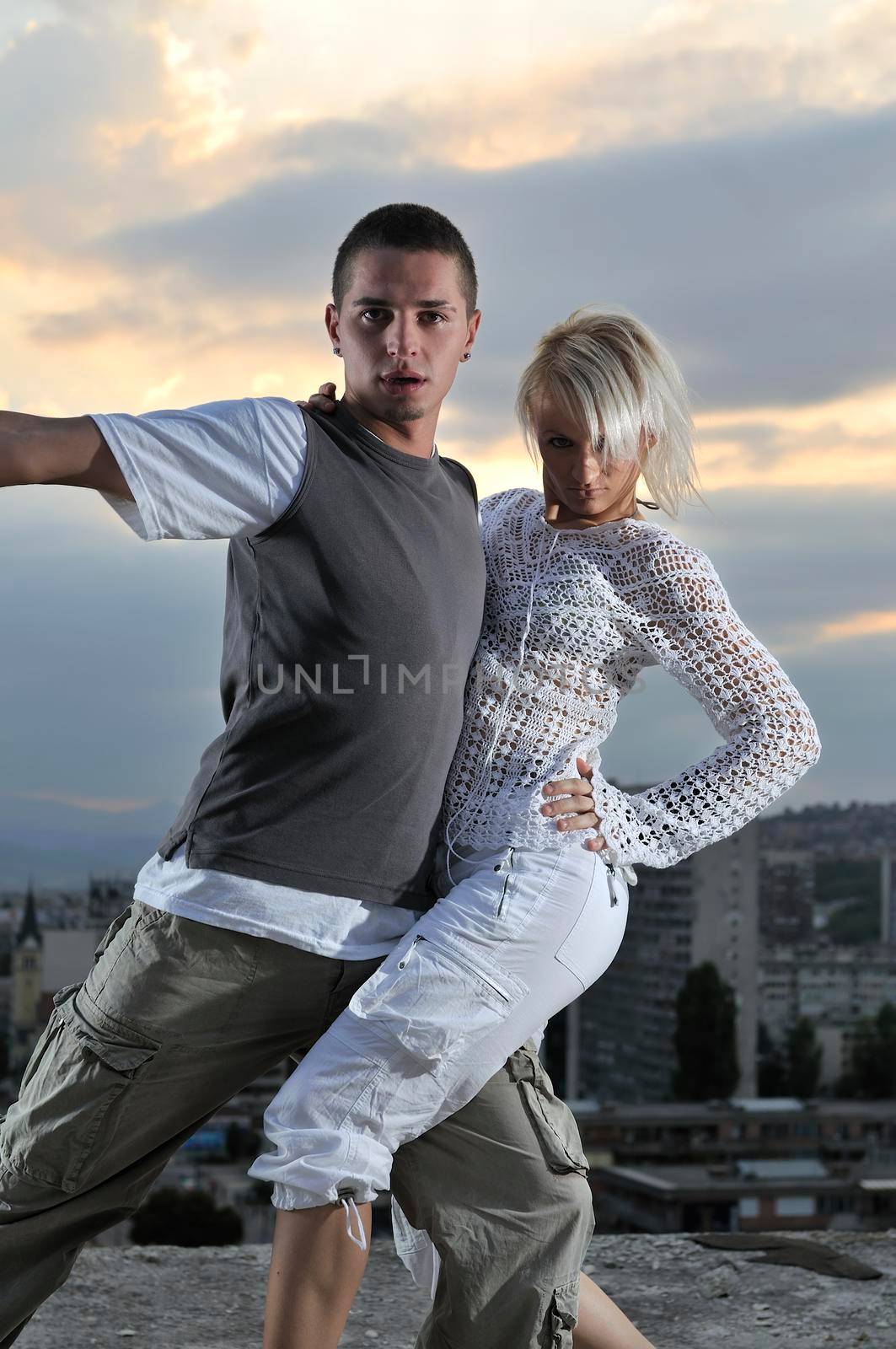 romantic urban couple dancing on top of the bulding  by dotshock