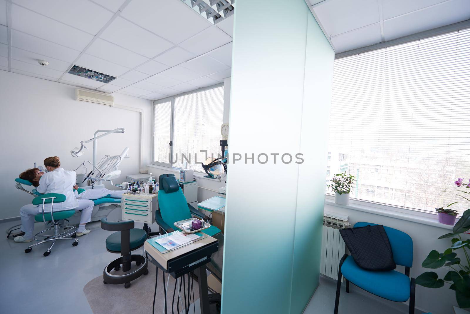 Closeup of a woman patient at the dentist waiting to be checked up with the woman doctor in the background