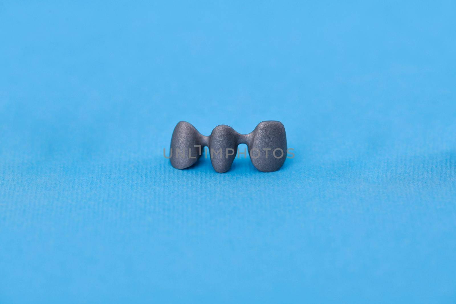 Dental silver metal tooth crowns isolated on blue background