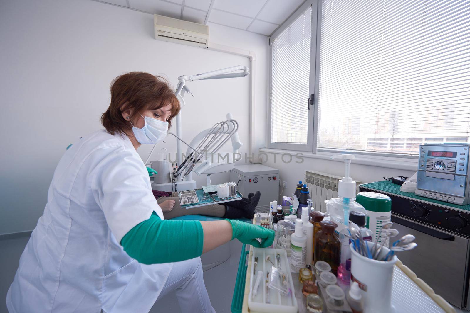 Closeup of a woman patient at the dentist waiting to be checked up with the woman doctor in the background