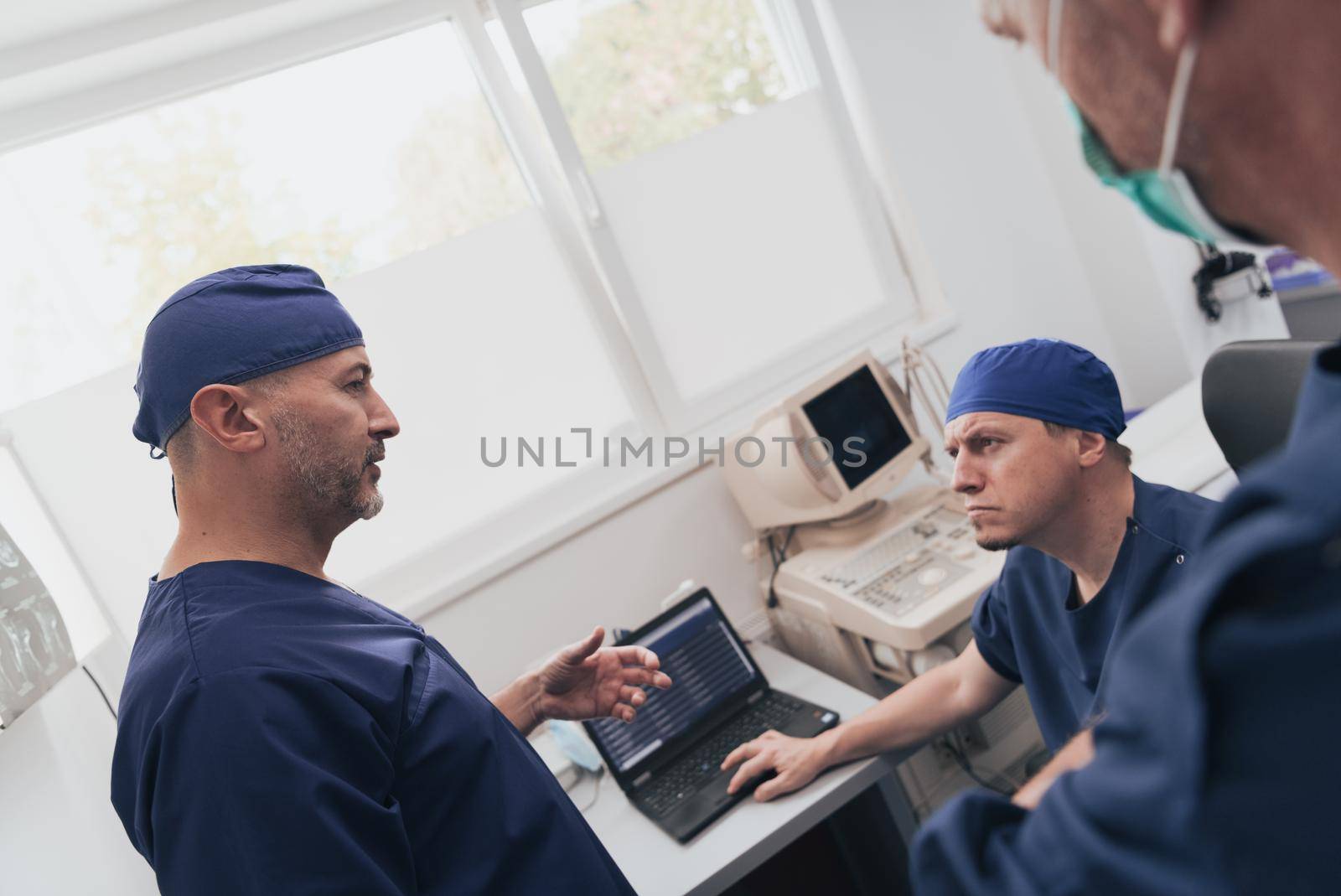 Orthopedist doctor team examining digital X-ray picture in clinic or hospital by dotshock
