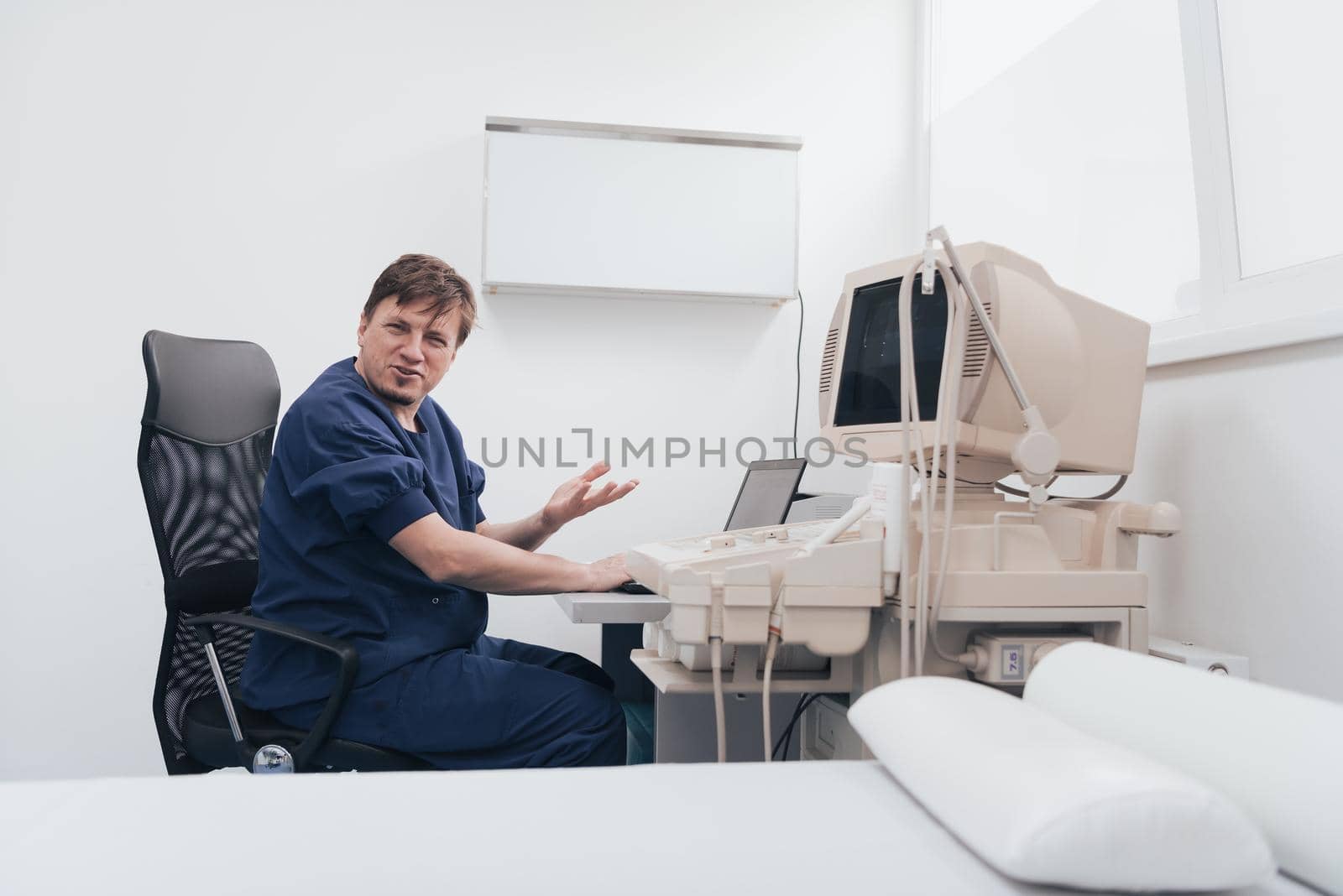 Orthopedist doctor examining X-ray picture at a desk in clinic on a laptop computer. High quality photo. Selective focus