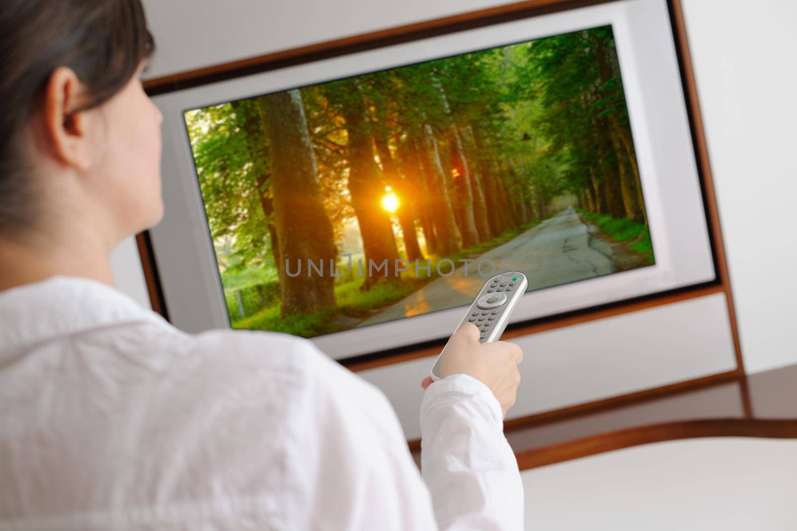 happy young woman watching tv at modern home livingroom