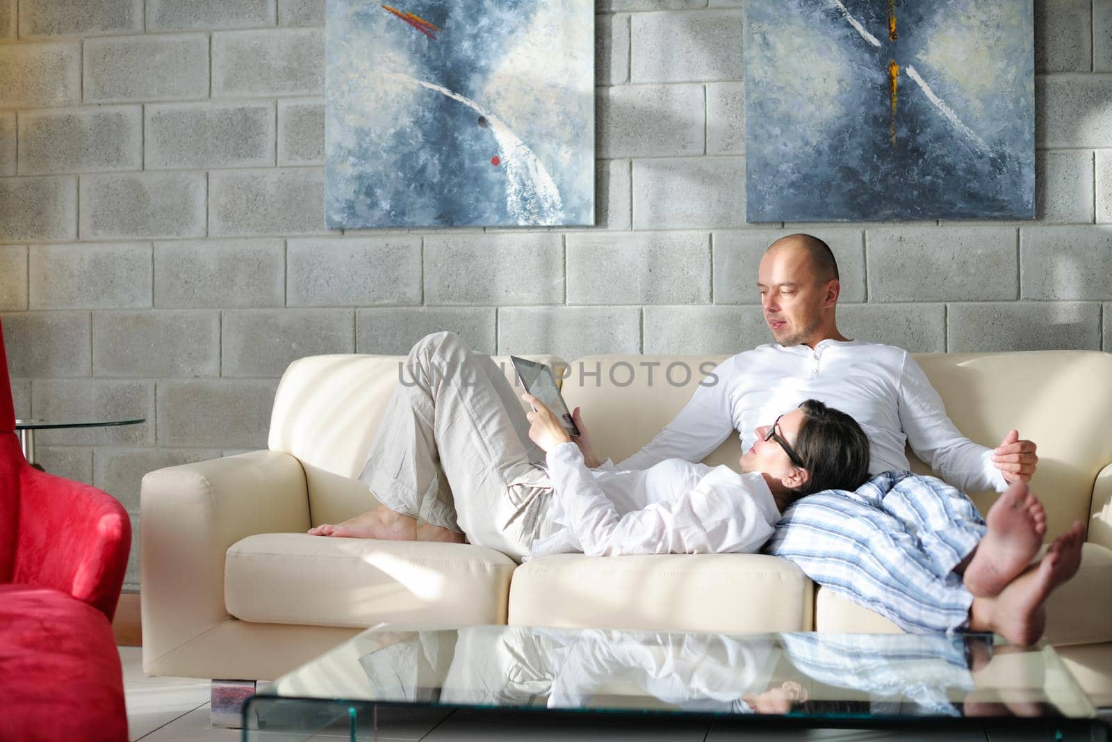 young couple using tablet computer at home by dotshock