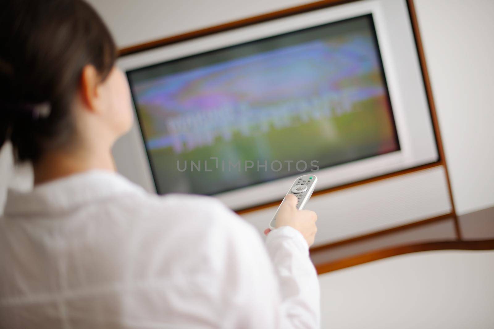 happy young woman watching tv at modern home livingroom