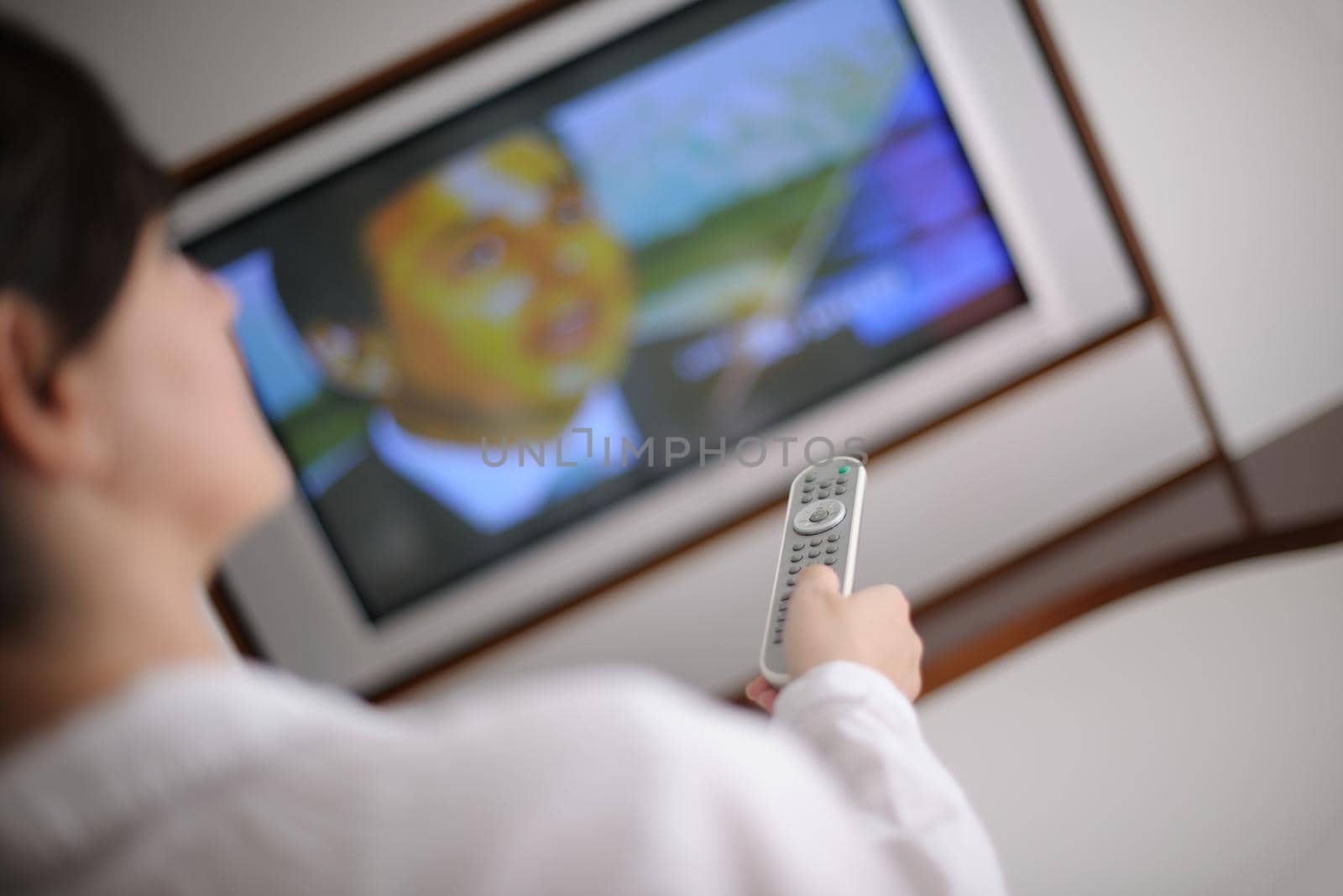 happy young woman relax at home on sofa in bright living room and watching tv