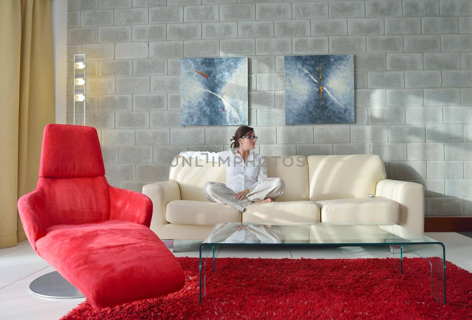 happy young woman relax at home on sofa in bright living room and watching tv