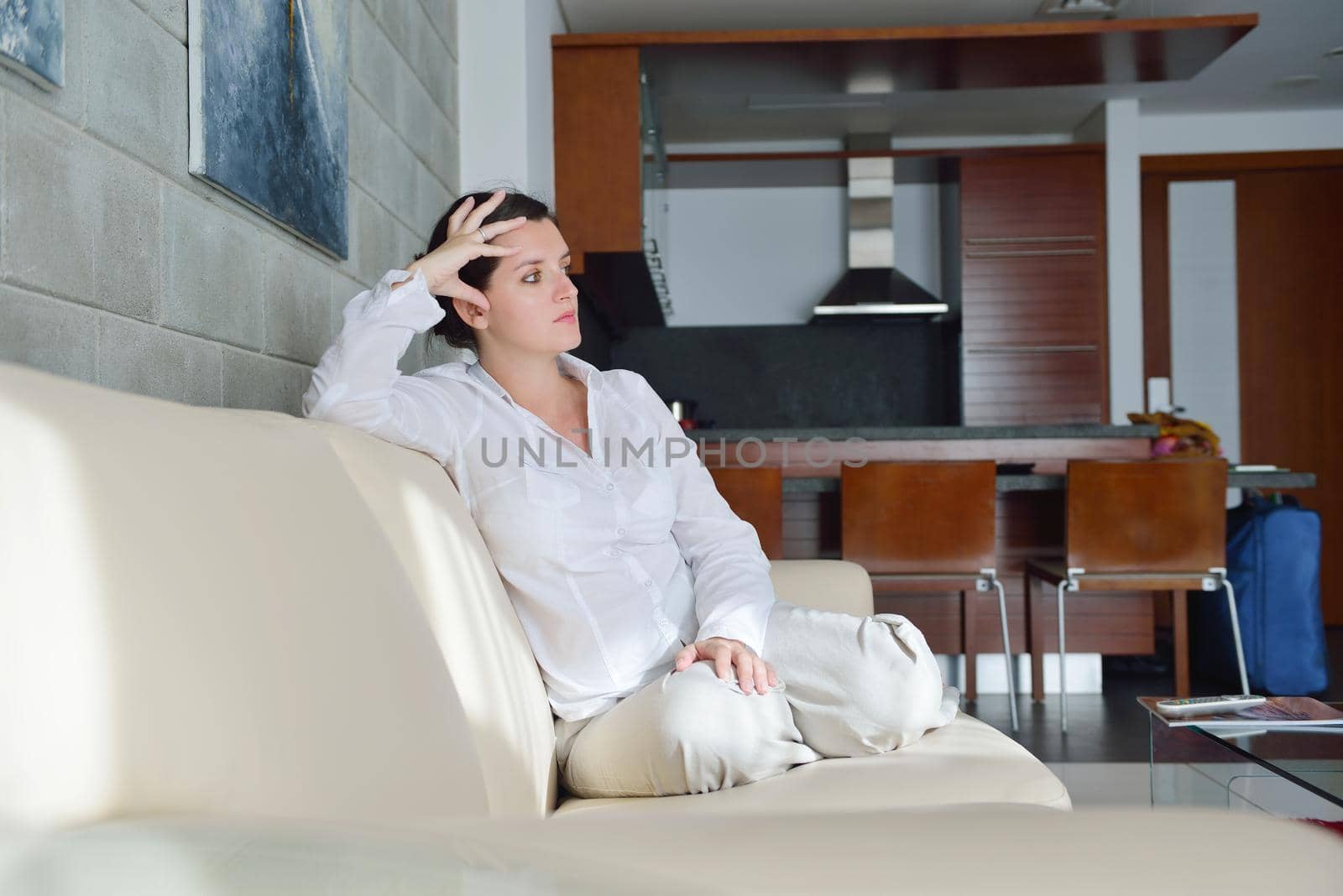 happy young woman relax at home on sofa in bright living room and watching tv