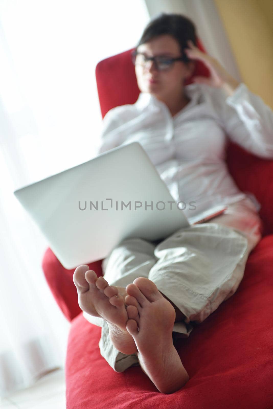 woman using a laptop computer at home by dotshock