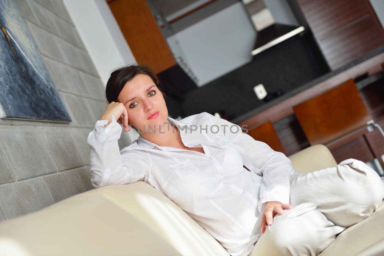 happy young woman relax at home on sofa in bright living room and watching tv