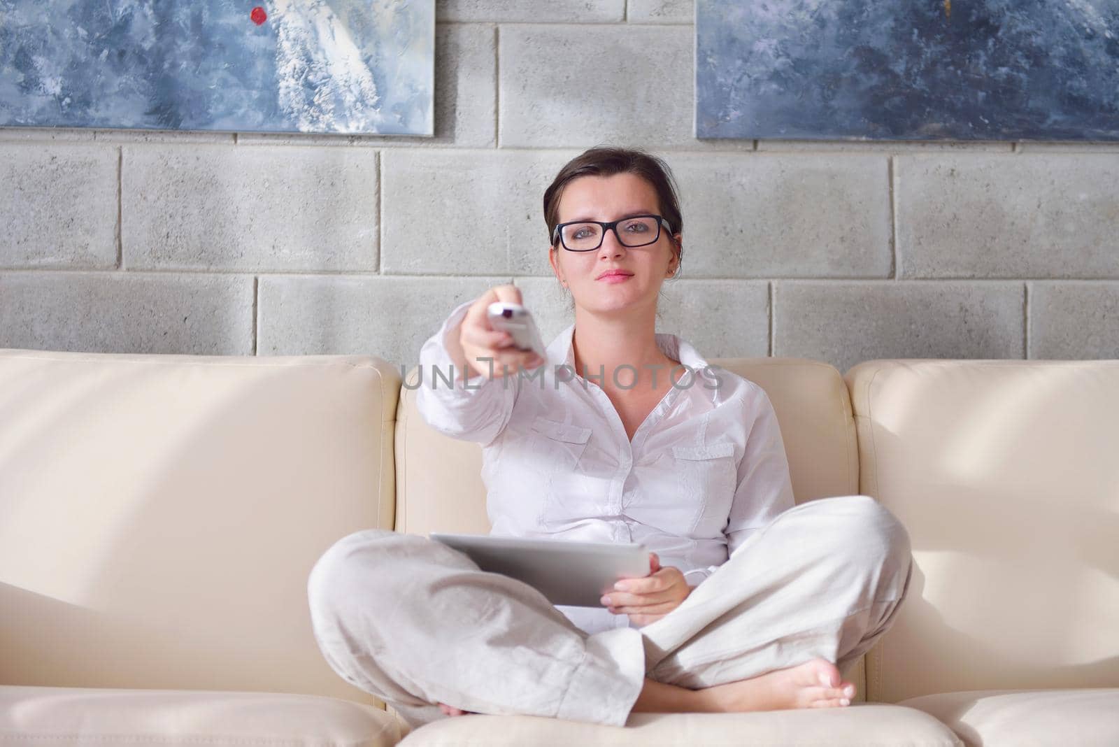 Young woman at home relaxing in her lliving room reading a digital tablet PC surf internet and work