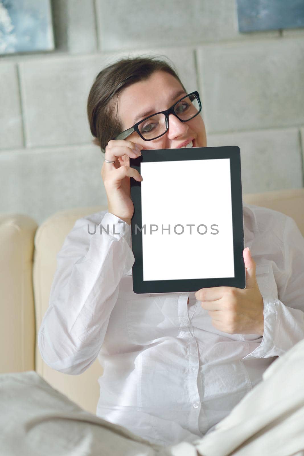 Young woman at home relaxing in her lliving room reading a digital tablet PC surf internet and work