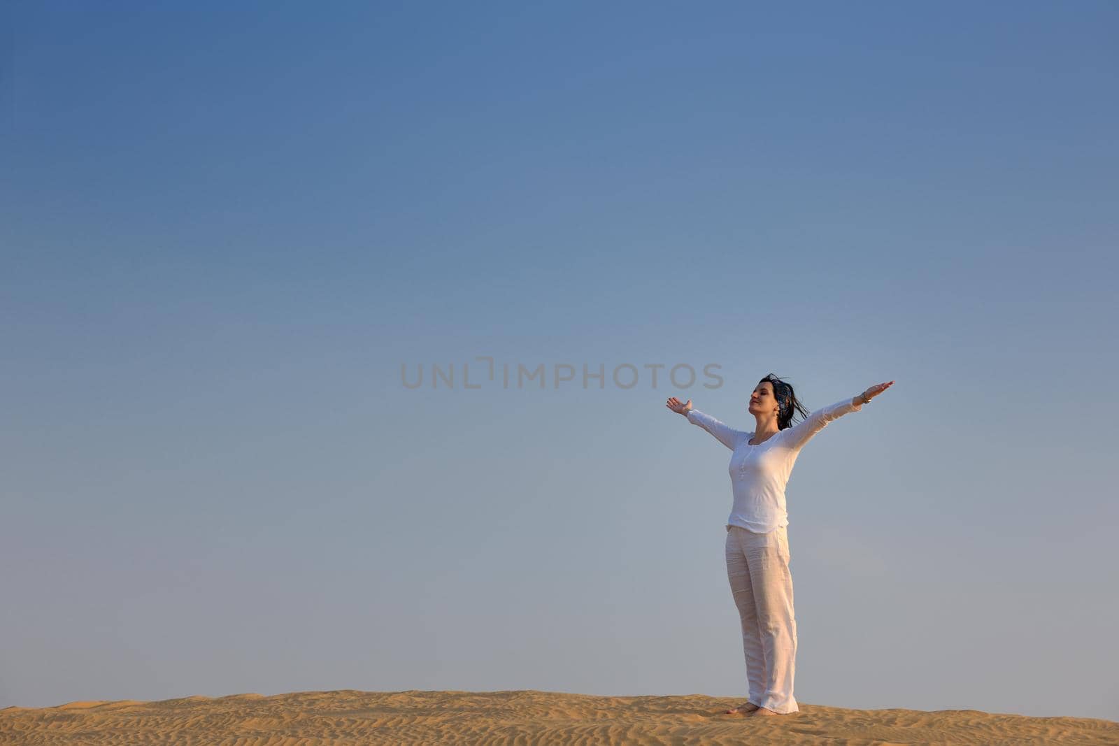 happy young woman relax and exercise yoga at desert in sunset