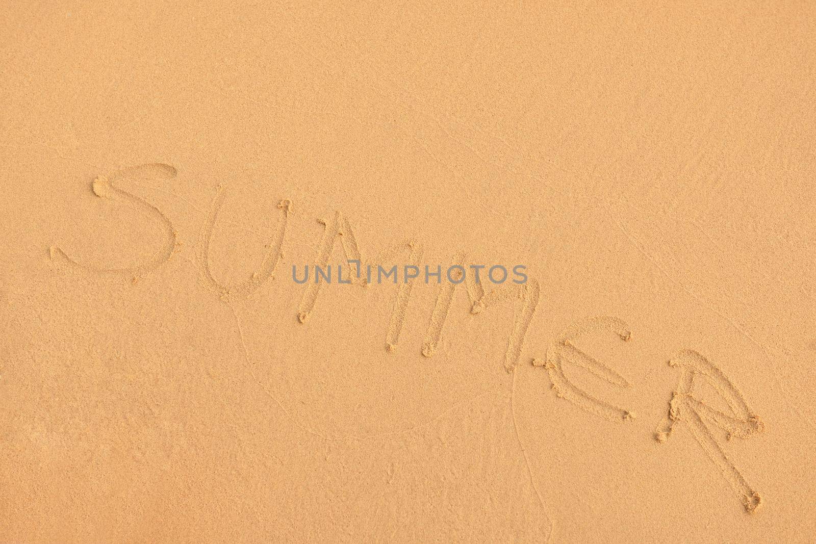 The Word Summer Written in the orange Sand background on a Beach at sunset