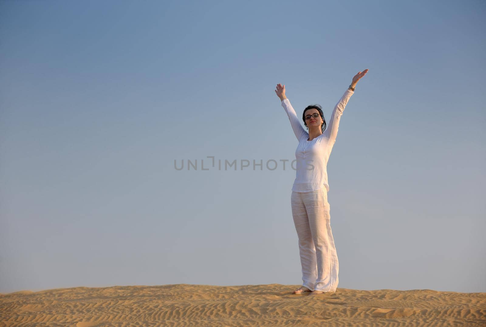 happy young woman relax and exercise yoga at desert in sunset