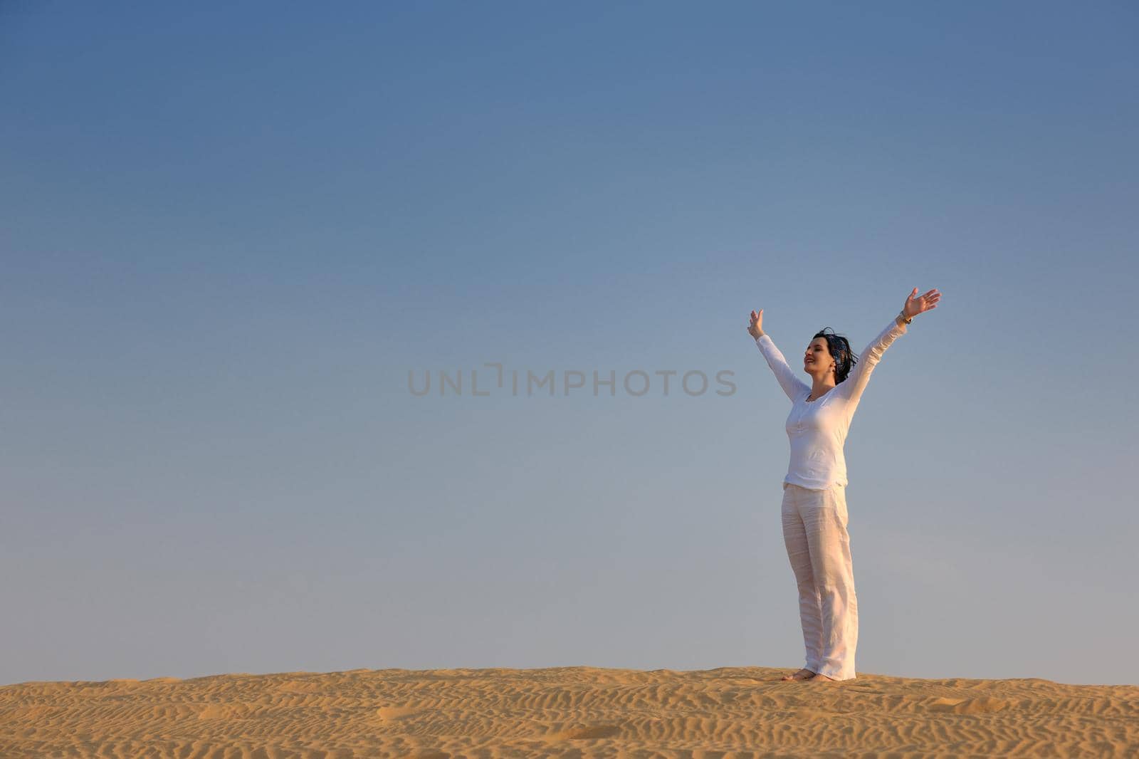 happy young woman relax and exercise yoga at desert in sunset