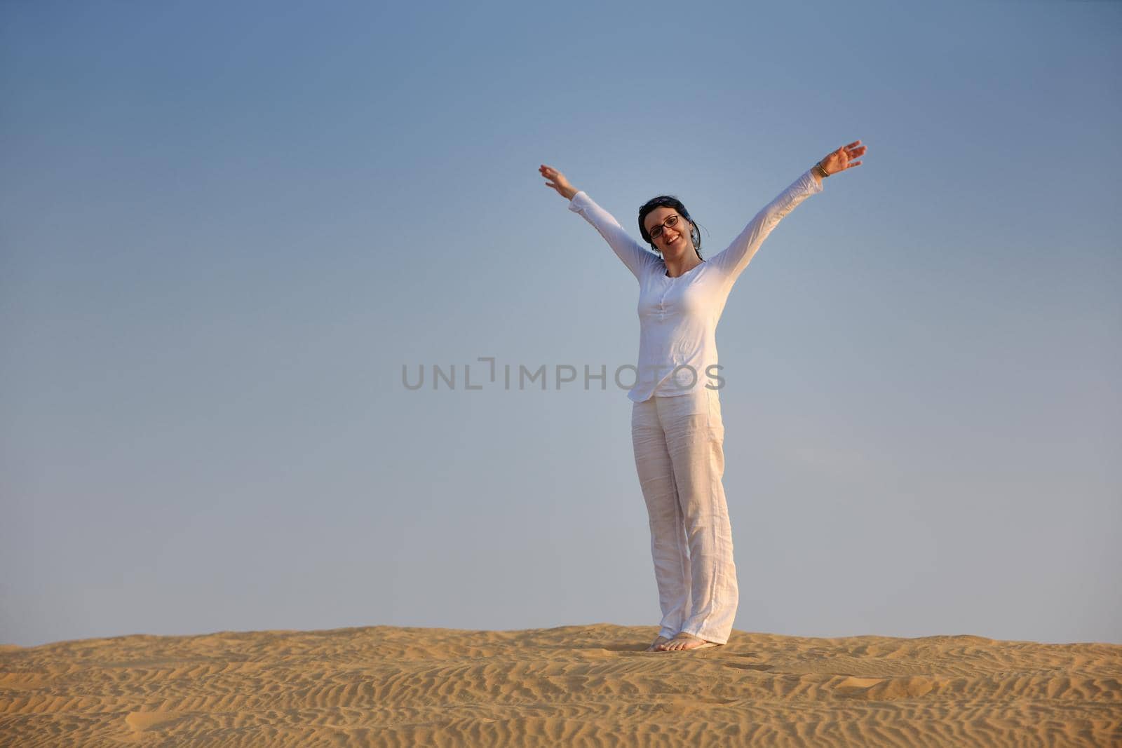 happy young woman relax and exercise yoga at desert in sunset