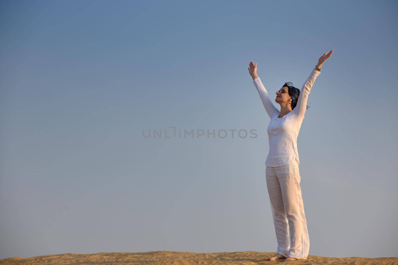 happy young woman relax and exercise yoga at desert in sunset