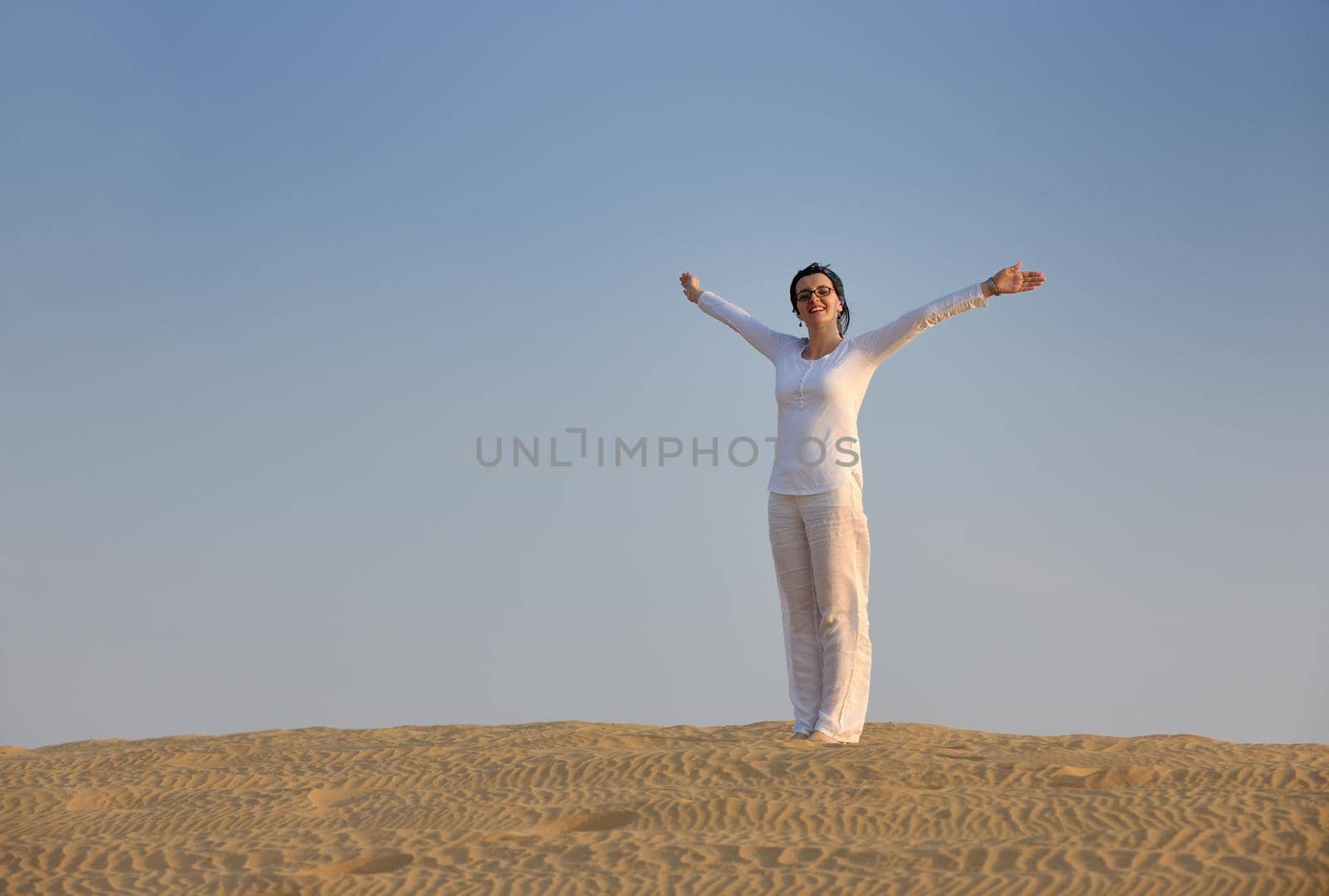 happy young woman relax and exercise yoga at desert in sunset