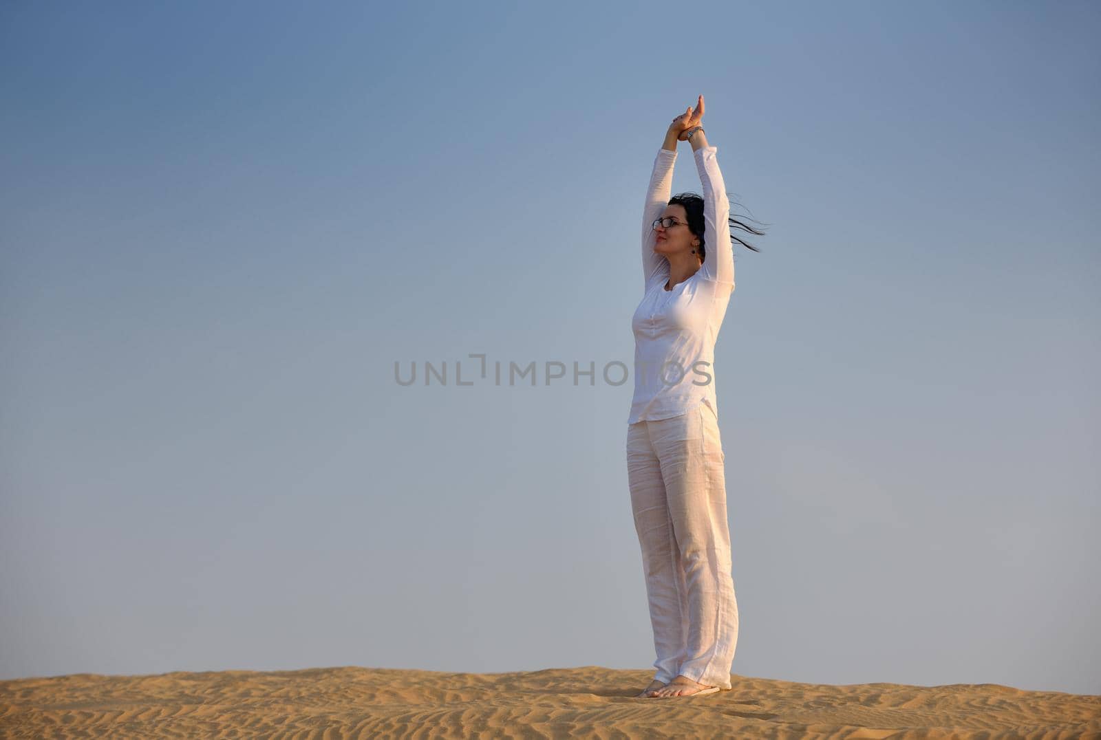 happy young woman relax and exercise yoga at desert in sunset