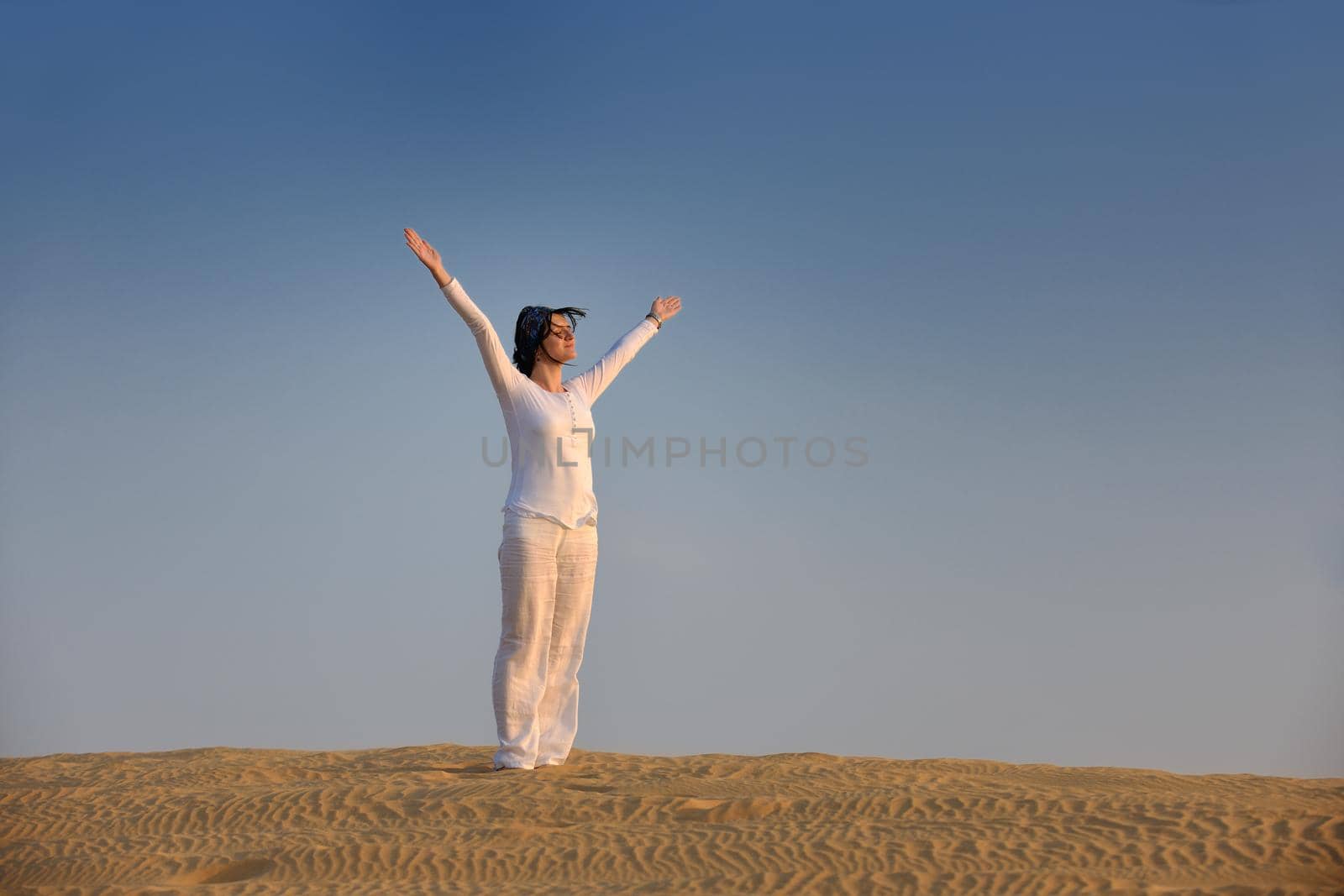 happy young woman relax and exercise yoga at desert in sunset