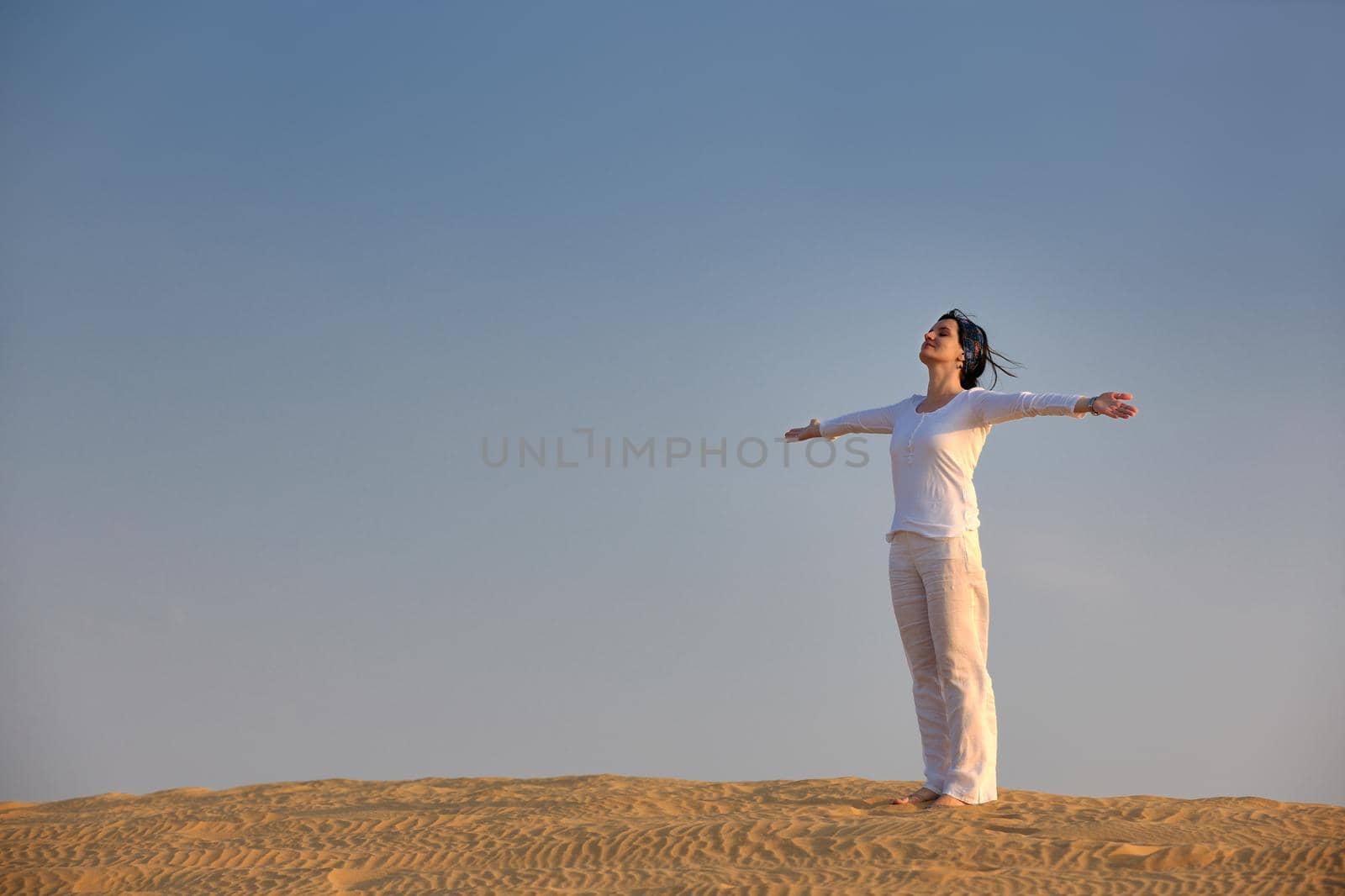 happy young woman relax and exercise yoga at desert in sunset