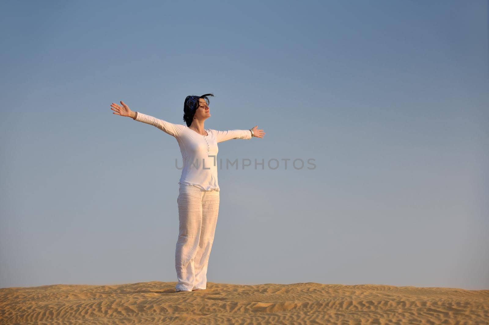 happy young woman relax and exercise yoga at desert in sunset