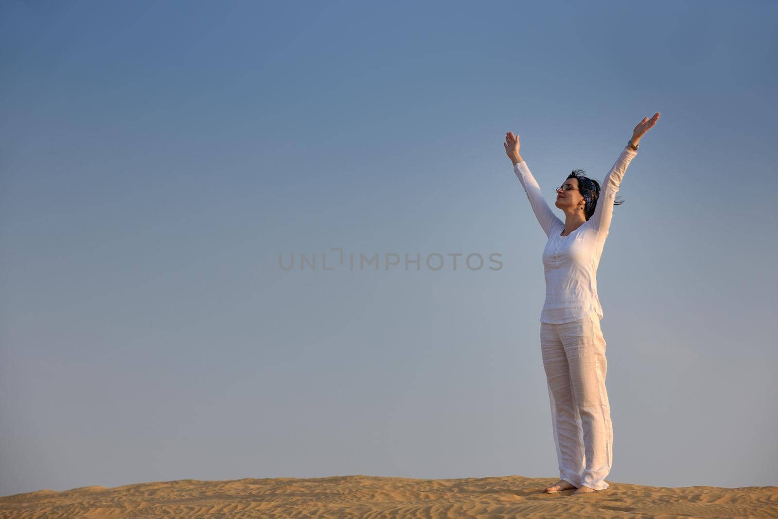 happy young woman relax and exercise yoga at desert in sunset