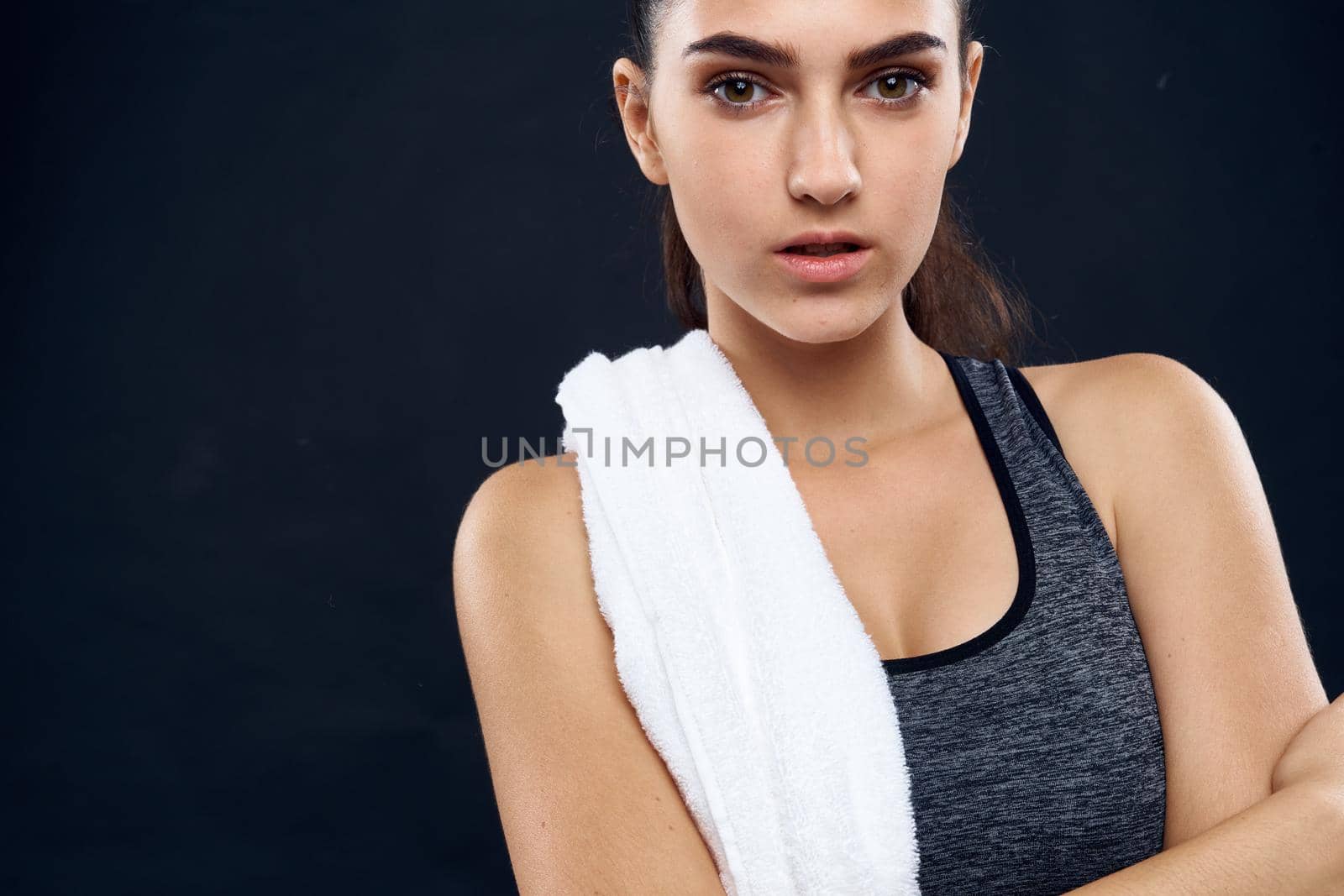 athletic woman with white towel gym slim figure dark background. High quality photo