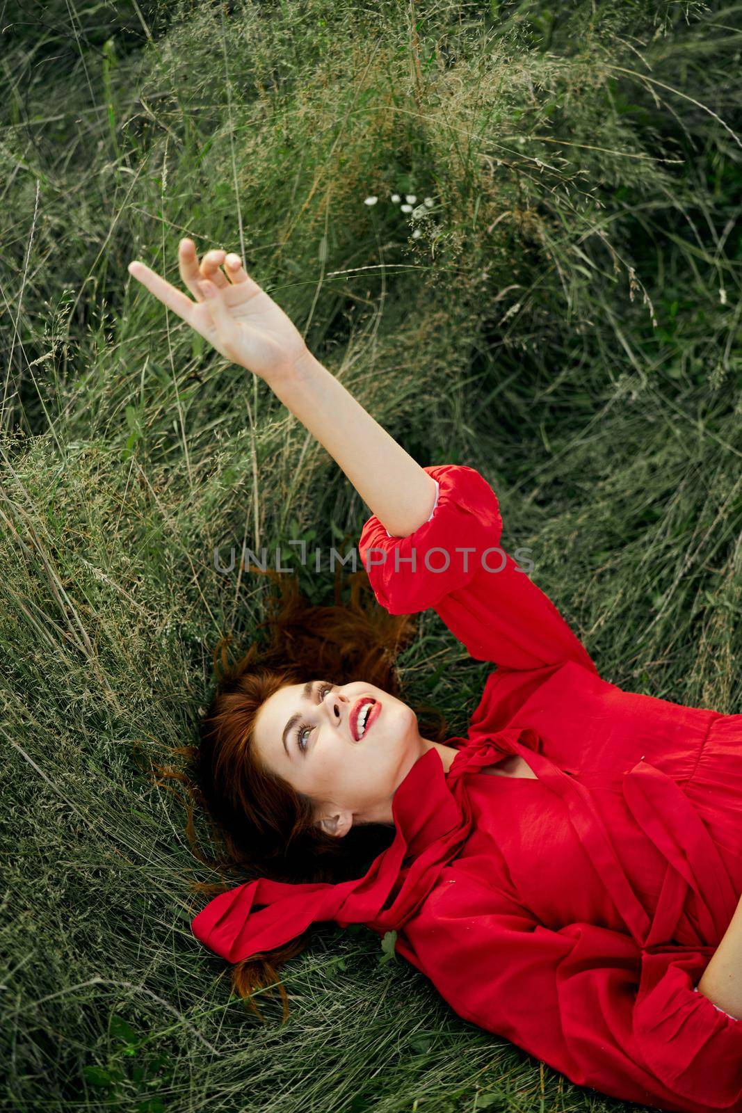 woman in red dress lies on the grass fresh air nature freedom by Vichizh