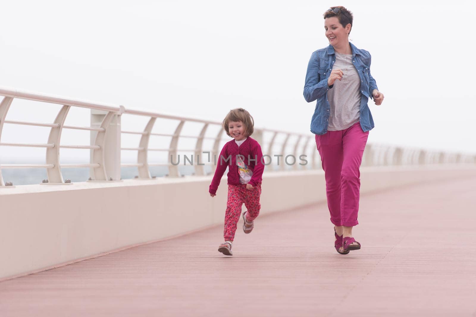 mother and cute little girl on the promenade by the sea by dotshock