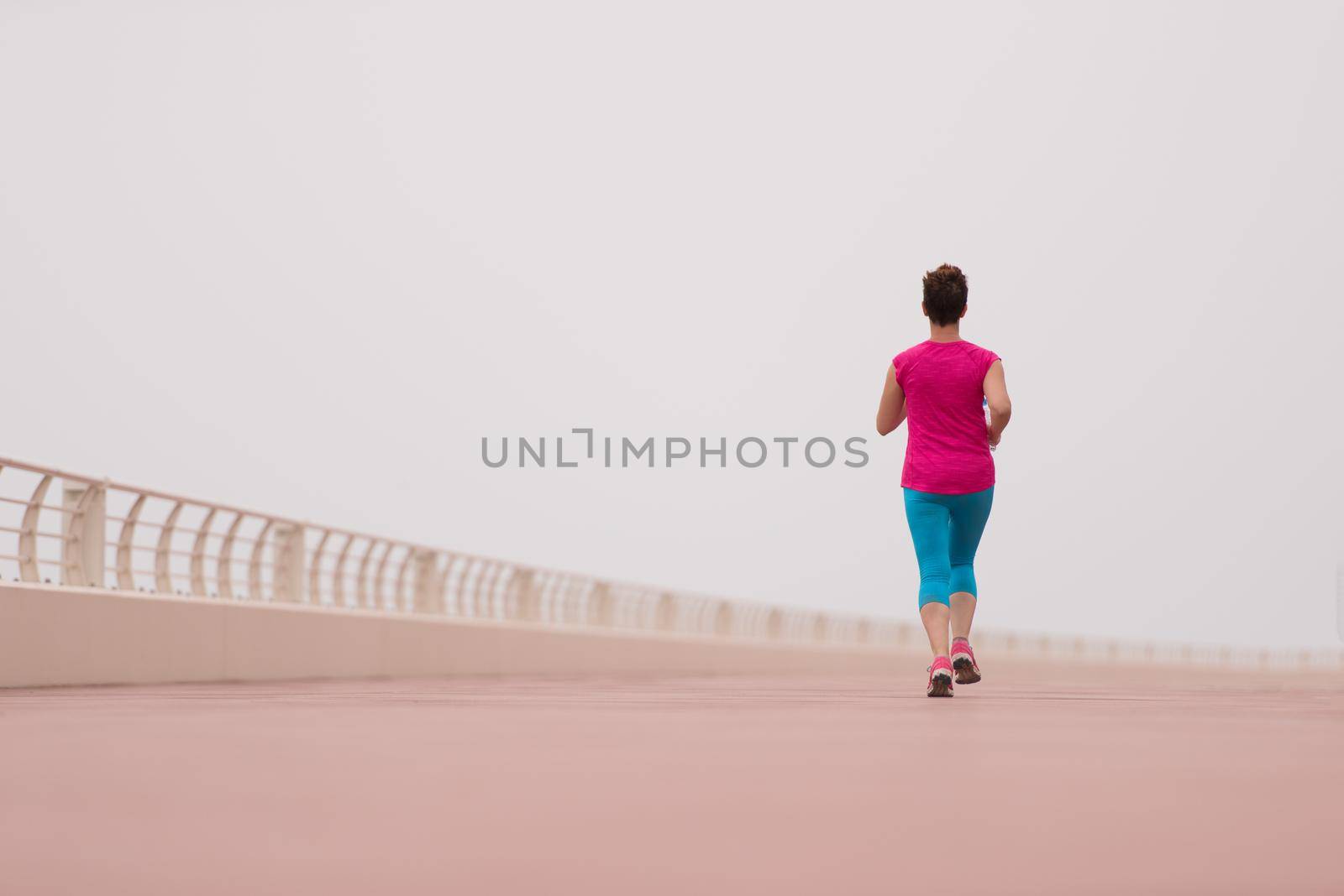 woman busy running on the promenade by dotshock