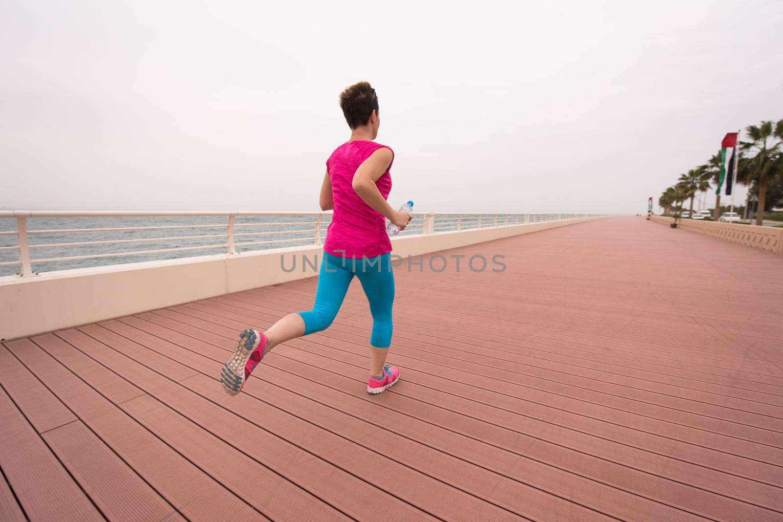 woman busy running on the promenade by dotshock