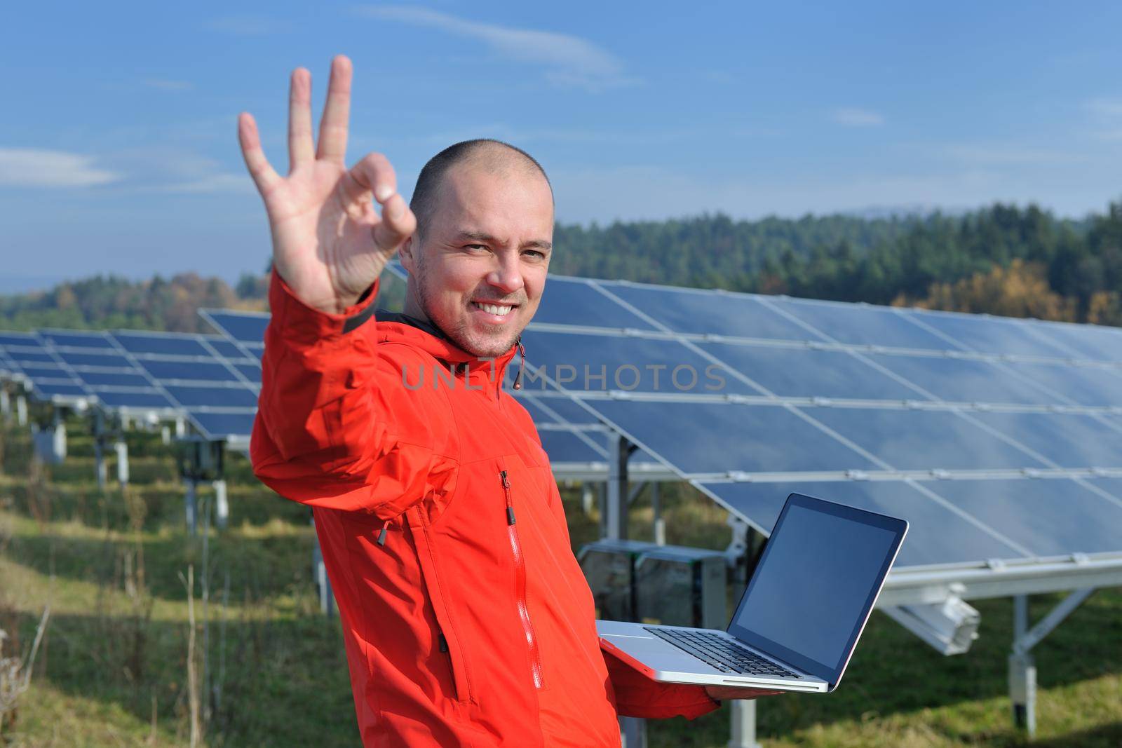 business man  engineer using laptop at solar panels plant eco energy field  in background