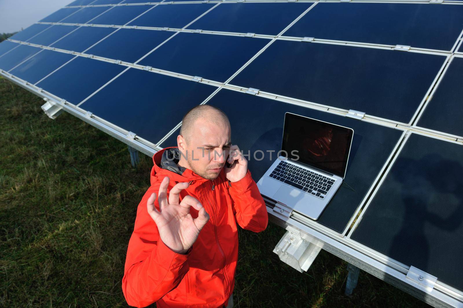 business man  engineer using laptop at solar panels plant eco energy field  in background