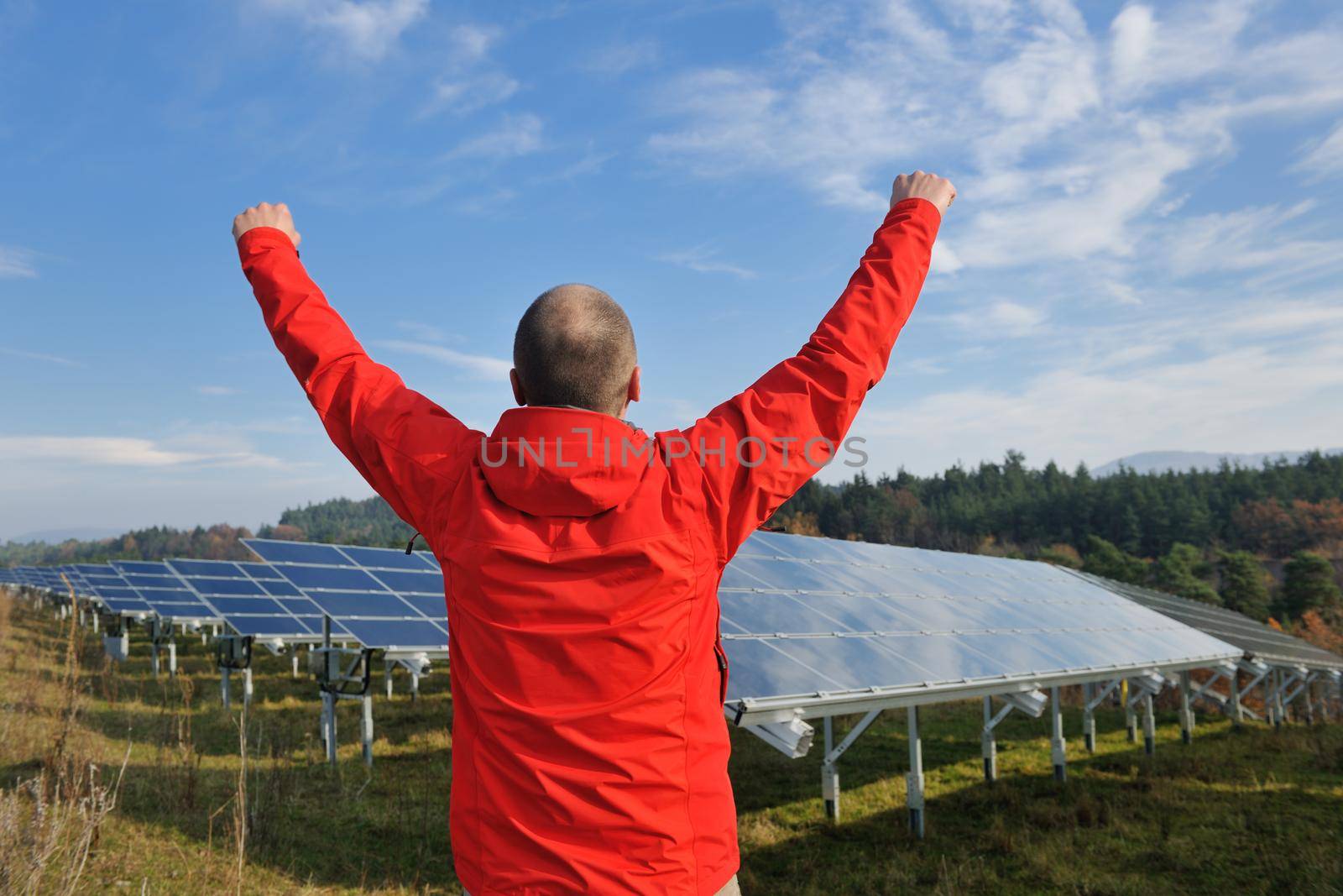 Male engineer at work place, solar panels plant industy in background