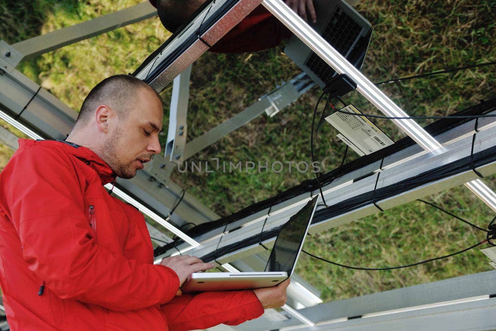 business man  engineer using laptop at solar panels plant eco energy field  in background