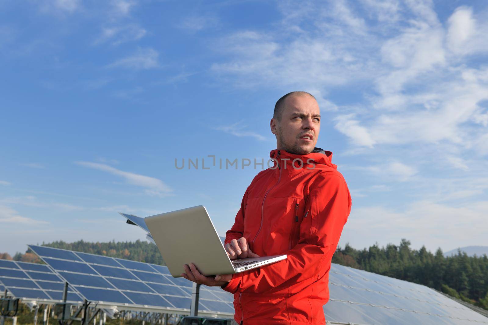 business man  engineer using laptop at solar panels plant eco energy field  in background